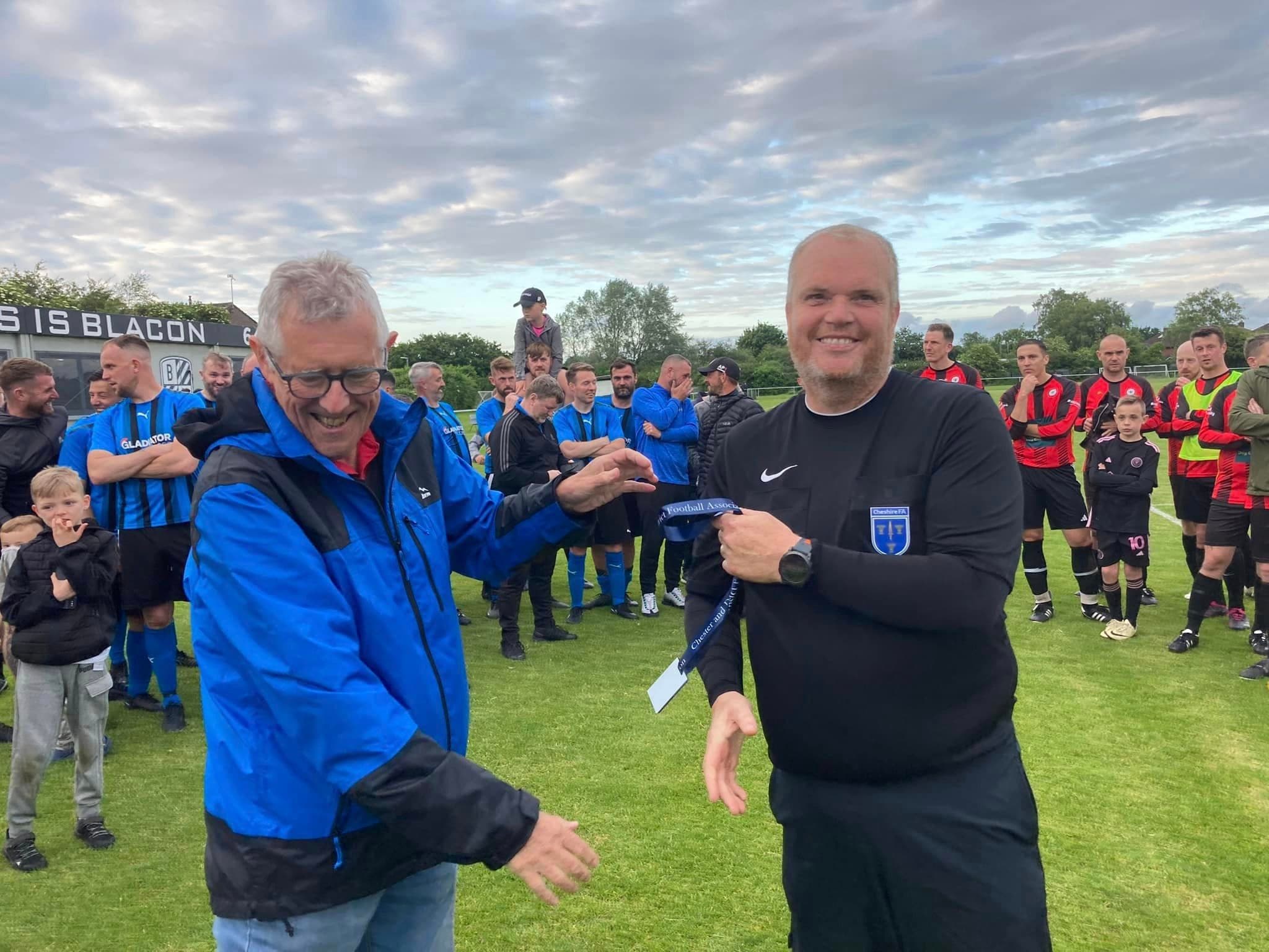 Referees walking together onto a local football pitch